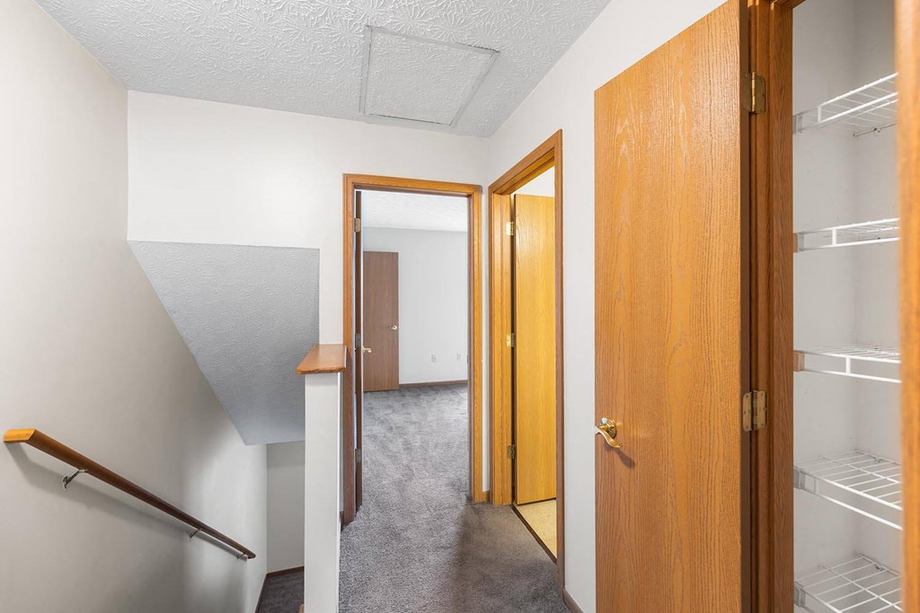 a room with a closet and a hallway with two doors