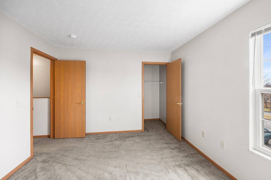 an empty living room with two doors and a window