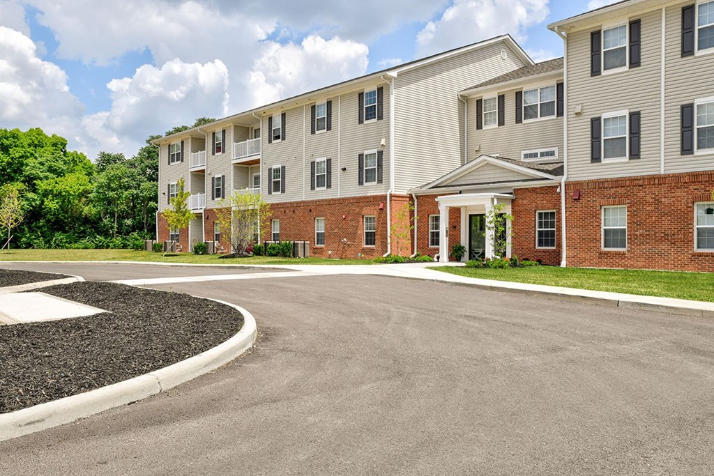 A large apartment complex with a parking lot in front.