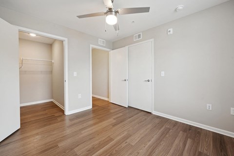 a living room with a ceiling fan and a closet