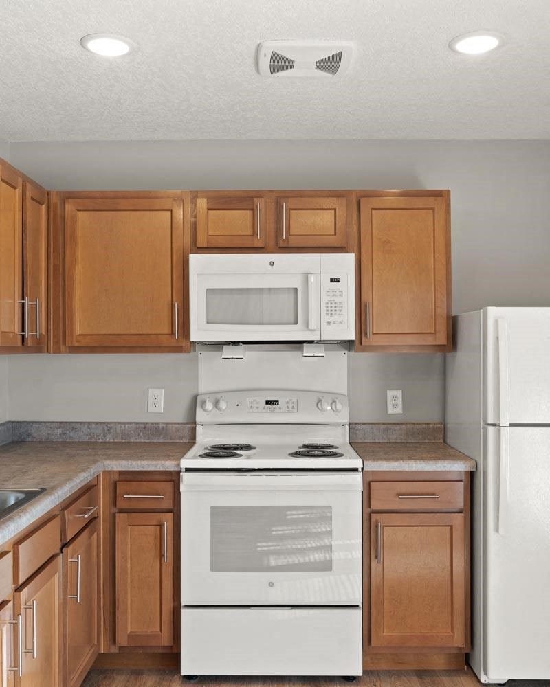 A kitchen with a white stove and white refrigerator.