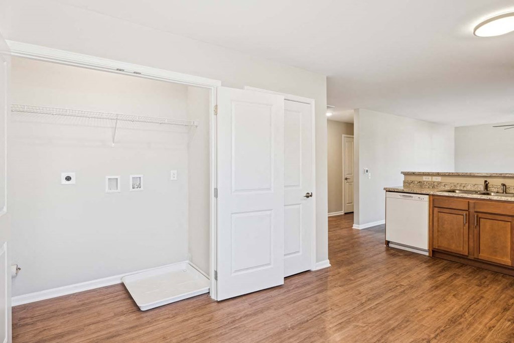 a living room with a kitchen and a door to a closet
