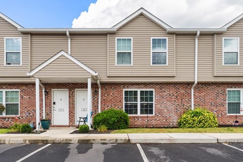 the front of a brick house with a white door