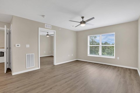A room with a ceiling fan and a window with blinds.
