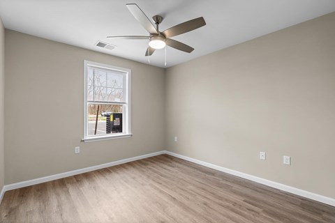 A room with a ceiling fan and a window.
