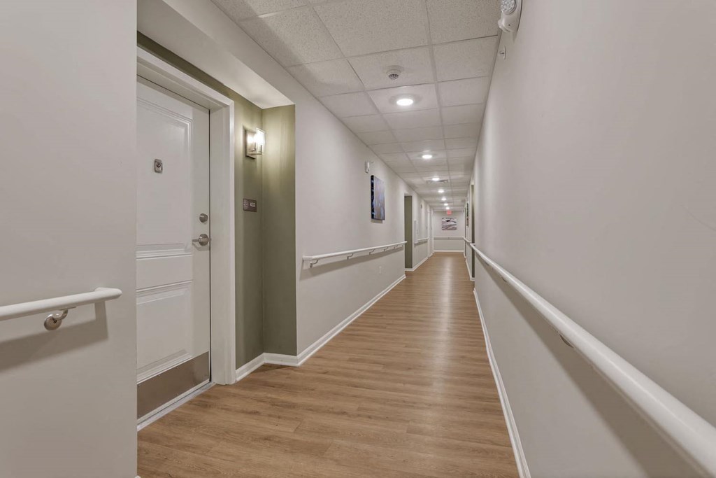 a long hallway with white walls and wood floors