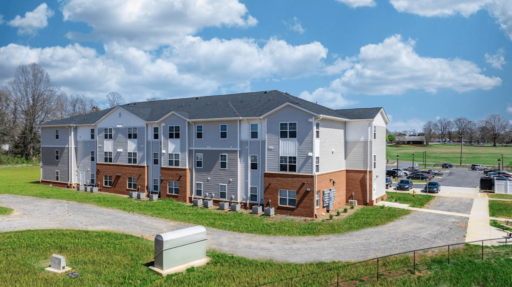 an apartment building with a driveway and a parking lot
