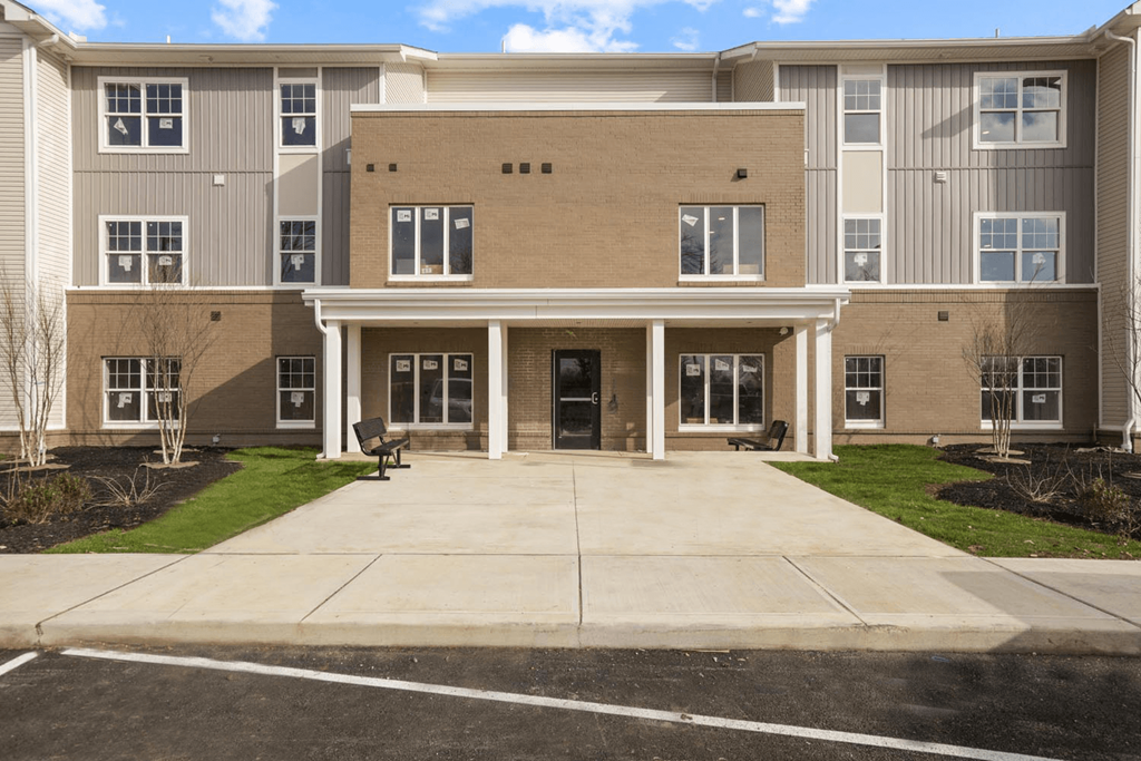 a large apartment building with a driveway and grass