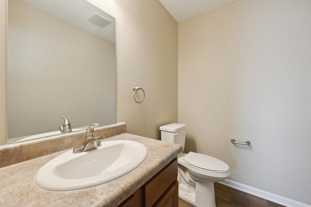 a bathroom with a sink toilet and mirror