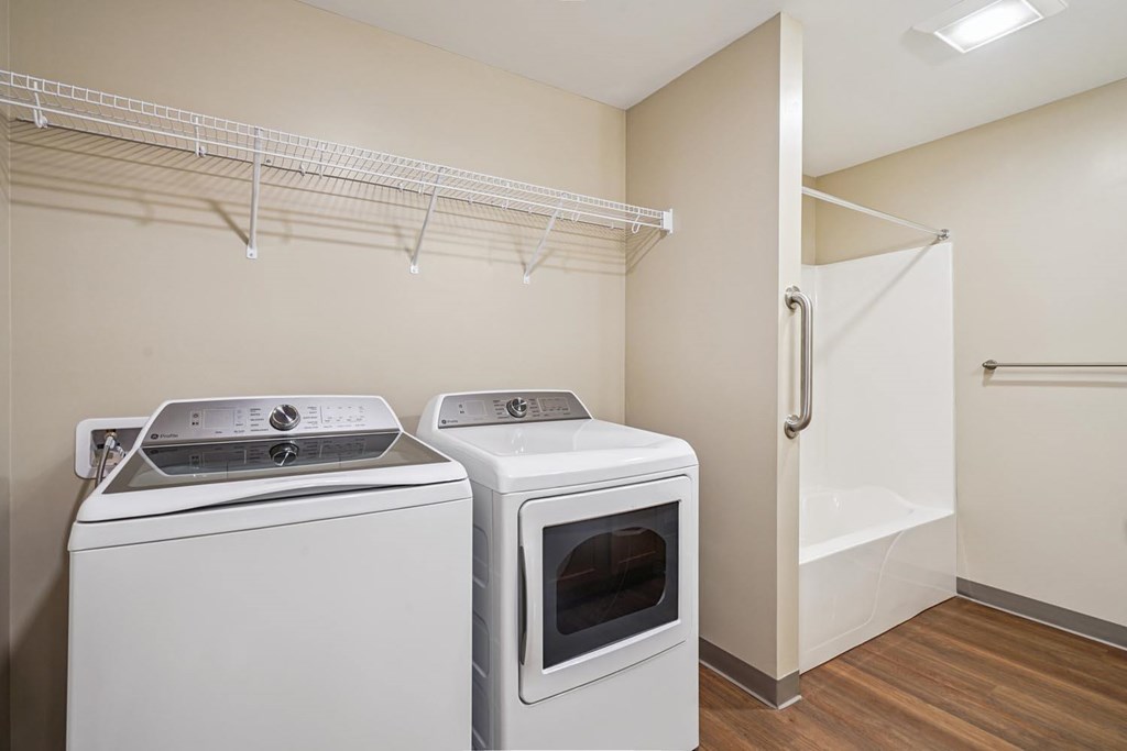 A white dryer and oven in a laundry room.