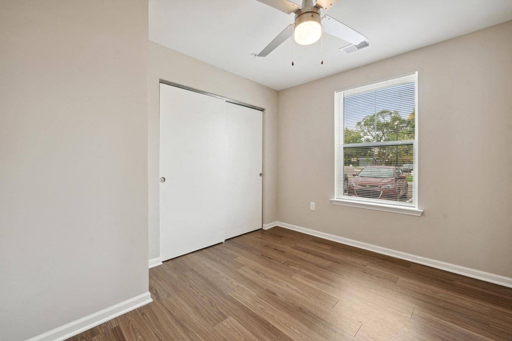 a bedroom with hardwood floors and a ceiling fan