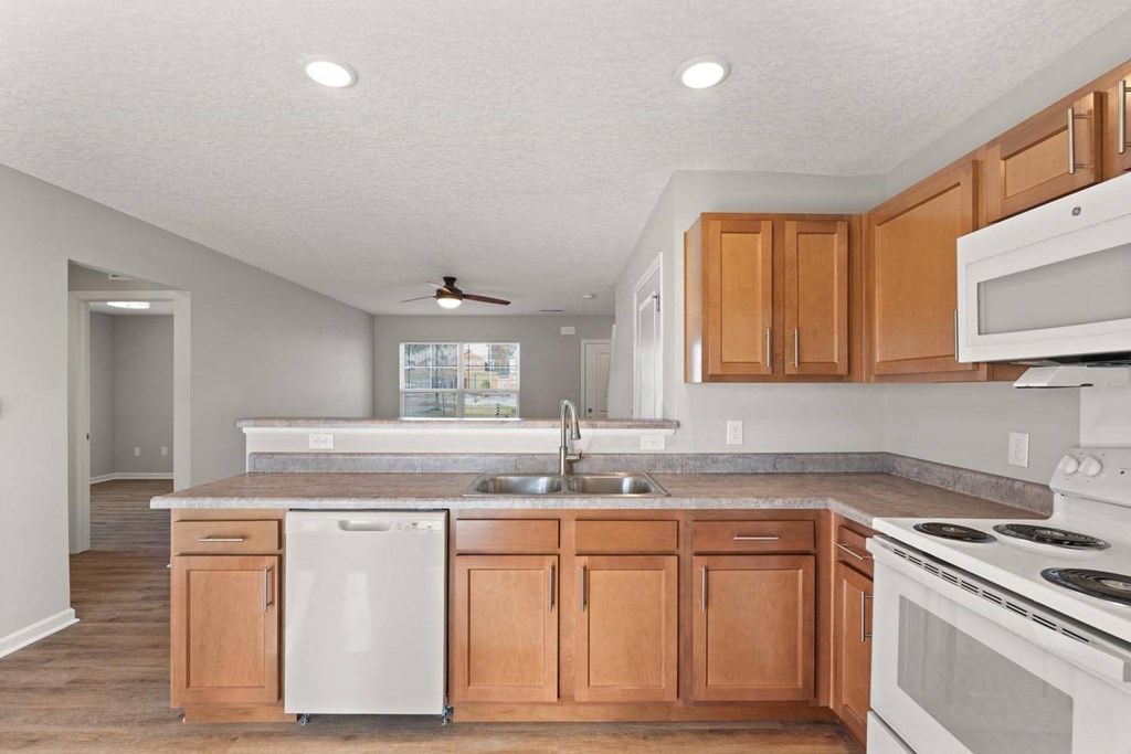 A kitchen with wooden cabinets and white appliances.