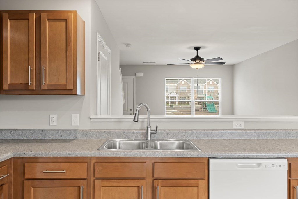 A kitchen with wooden cabinets and a white dishwasher.