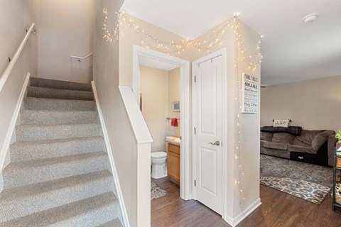 a living room with a door to a bathroom and a staircase