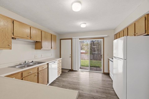 A kitchen with wooden cabinets and a white refrigerator.