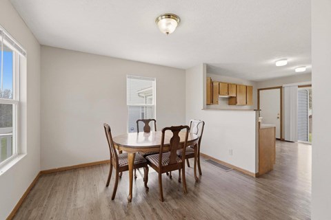 A dining room with a table and chairs.