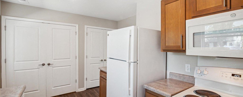a kitchen with a white refrigerator freezer next to a stove top oven