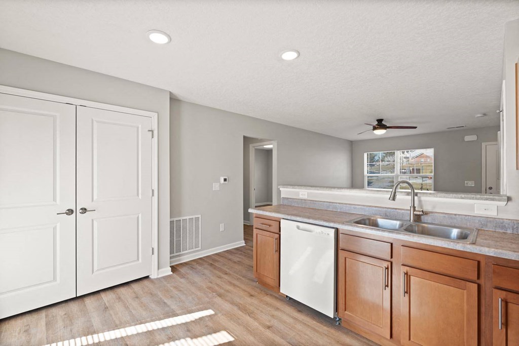 A kitchen with white cabinets and a white dishwasher.
