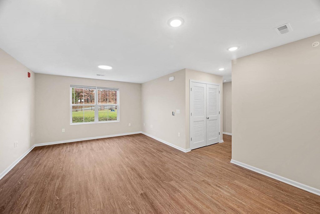 A room with wooden flooring and a white cabinet.