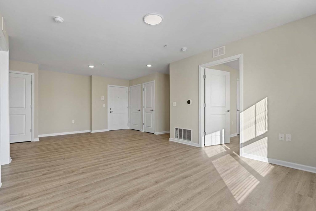 an empty living room with wood flooring and white walls