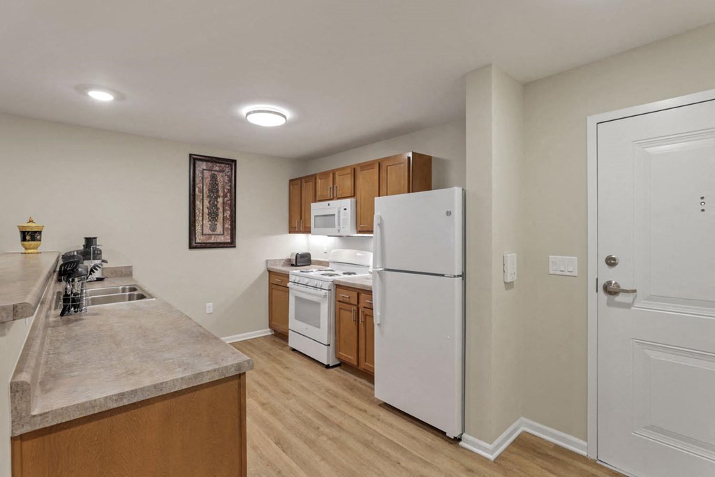 a kitchen with a white refrigerator and a sink