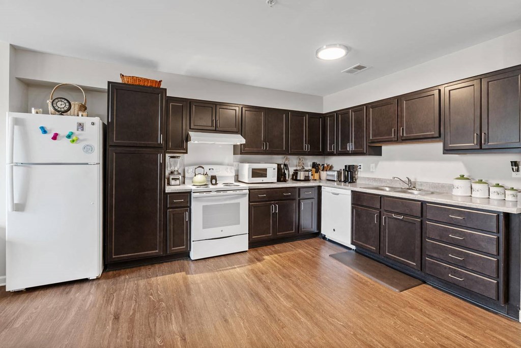 a kitchen with dark wood cabinets and white appliances