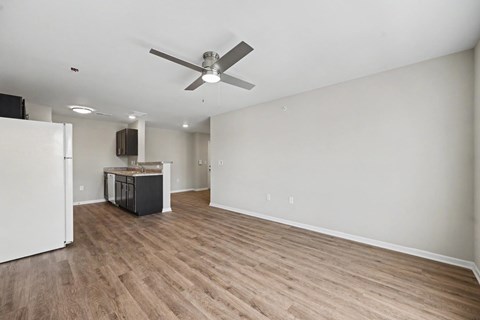 A room with a ceiling fan and wooden flooring.