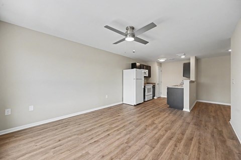 A room with a ceiling fan and wooden flooring.