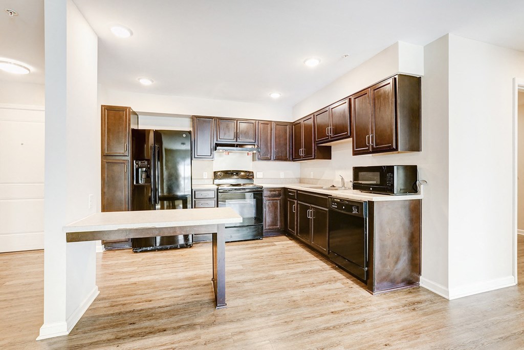 a kitchen with black appliances and wooden cabinets