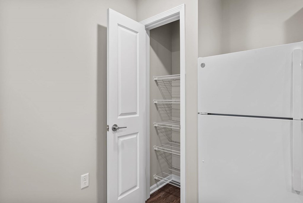A white door is open to a white fridge.