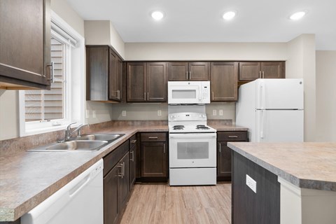A kitchen with brown cabinets and a white stove top oven.
