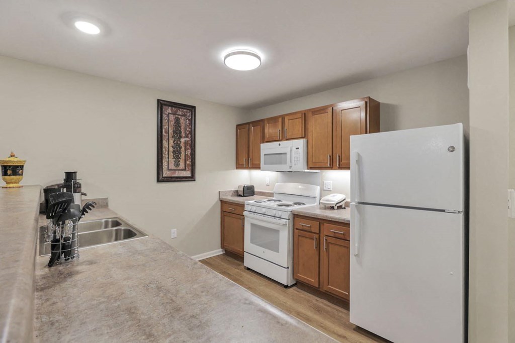 a kitchen with white appliances and wooden cabinets