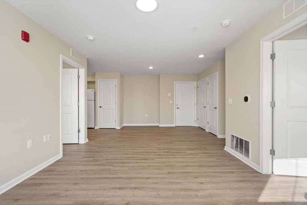 an empty living room with white walls and wood floors