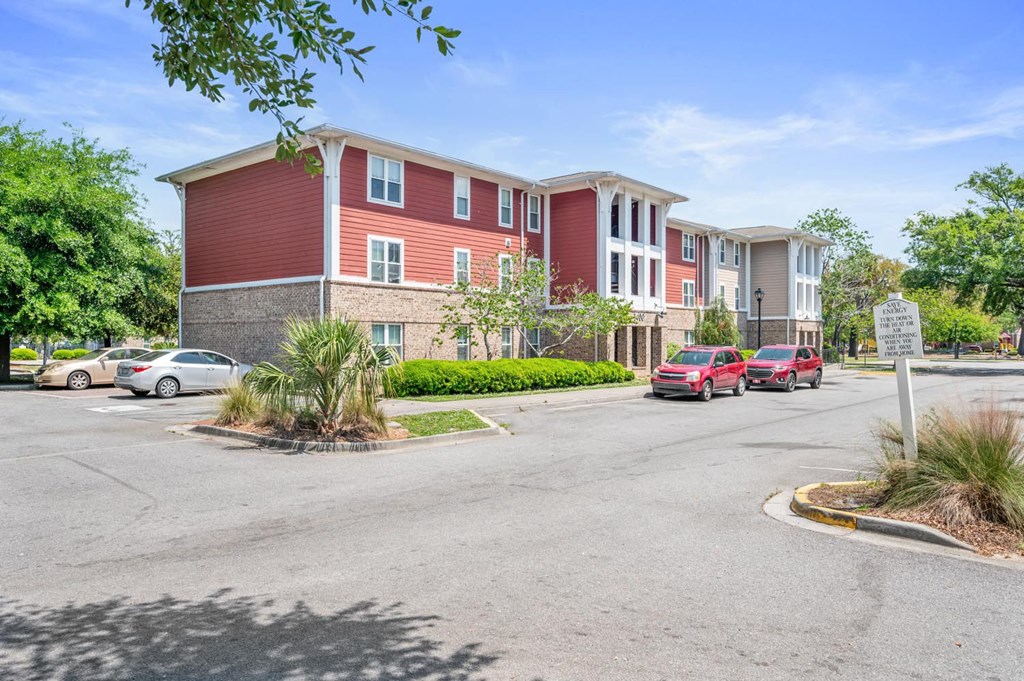 a street view of an apartment building with cars parked in front