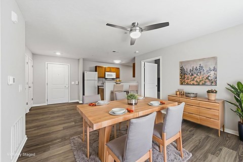 A dining room with a wooden table and chairs.