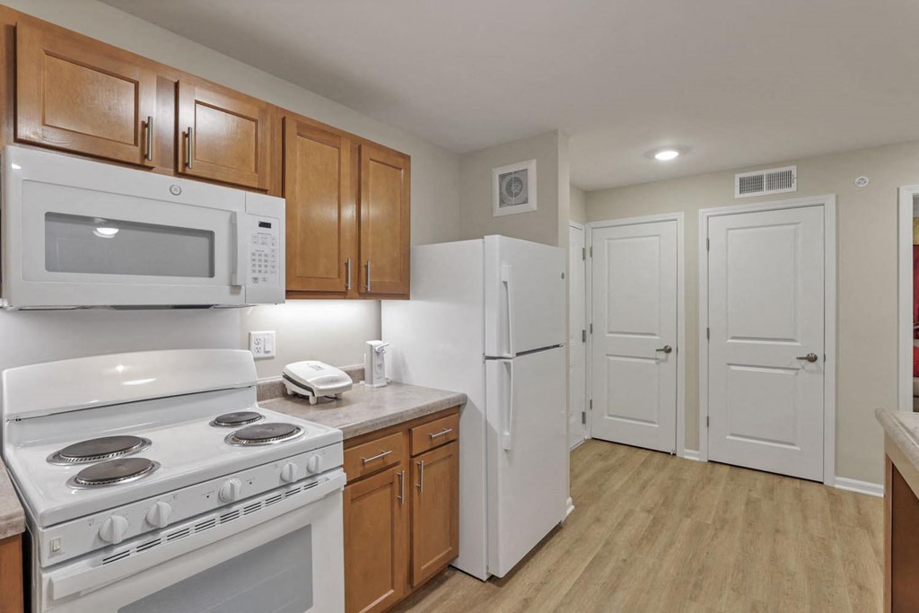 a kitchen with white appliances and wooden cabinets