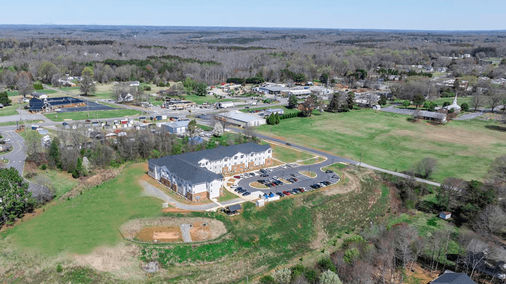 an aerial view of a school with a field and a building