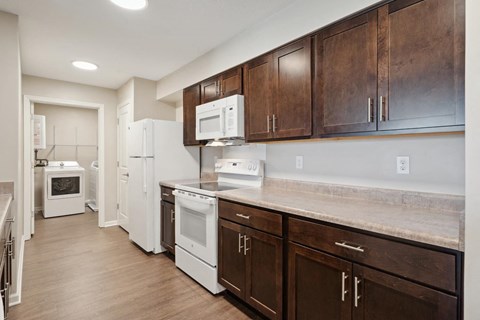 a kitchen with white appliances and wooden cabinets