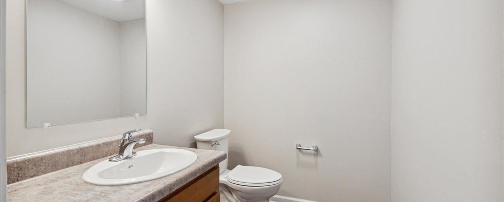 a bathroom with a sink toilet and mirror
