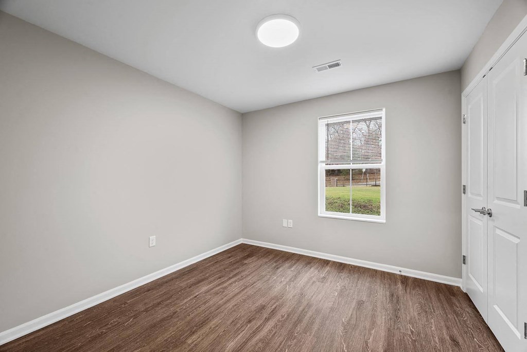 A room with a window and a picture on the wall.