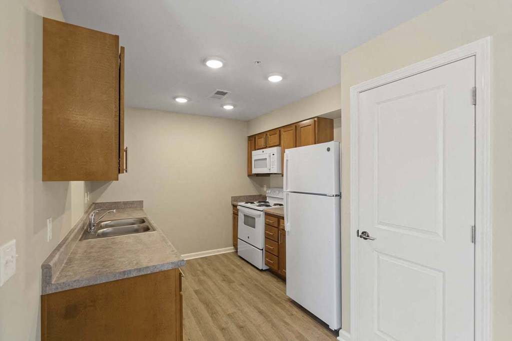 a kitchen with a white refrigerator and a sink