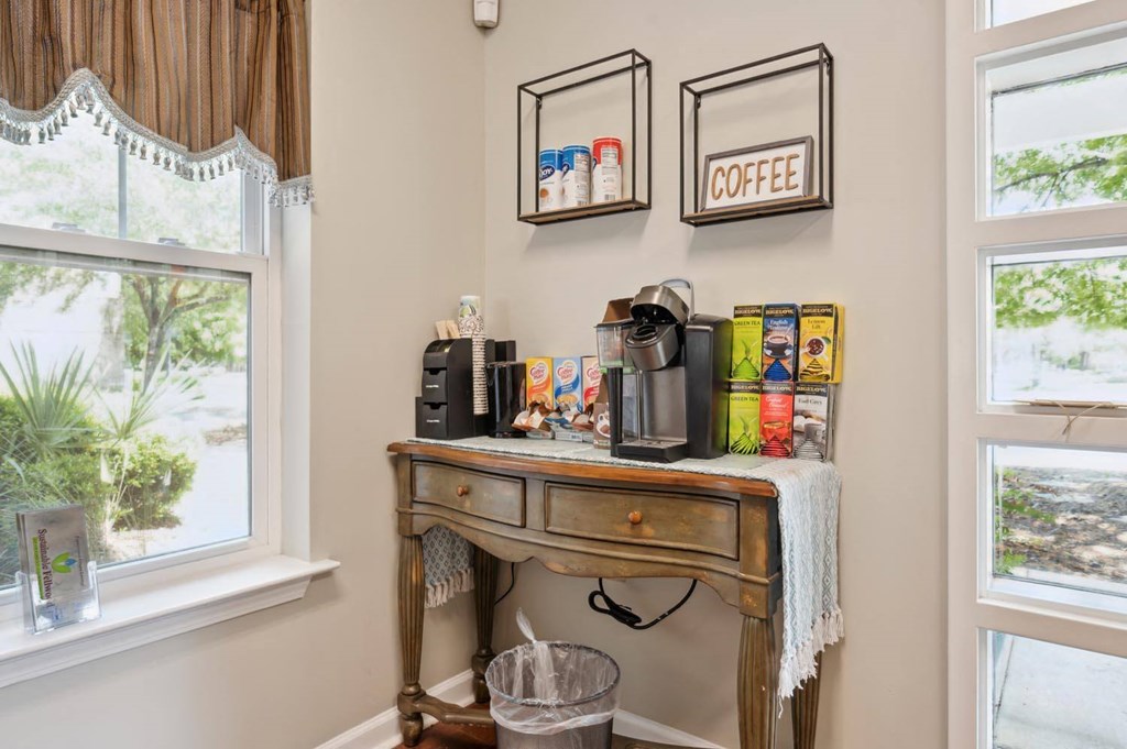 a corner of a kitchen with a table with coffee and other items on it