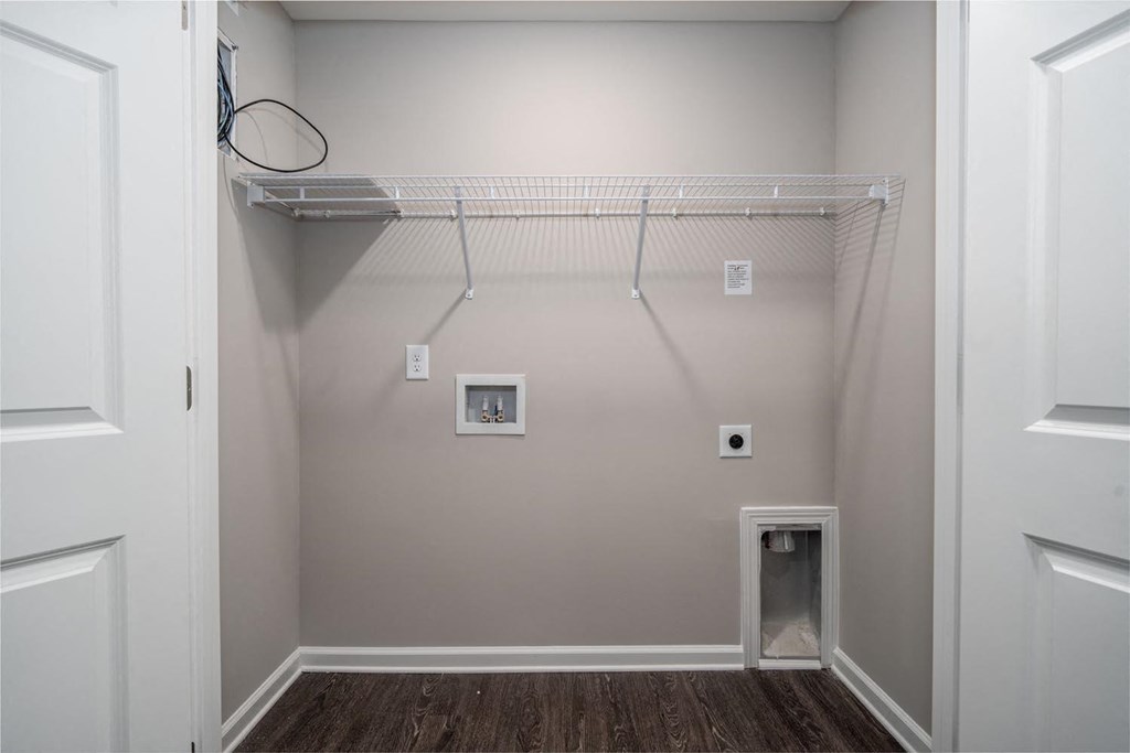 a walk in closet in a home with a white wall and a closet organizer