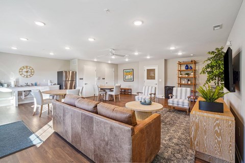 A living room with a brown couch and a white dining table.