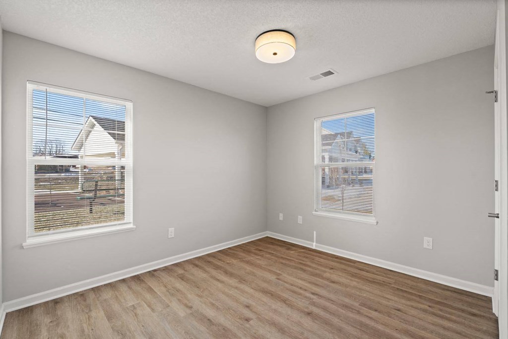 A room with a window and a wooden floor.