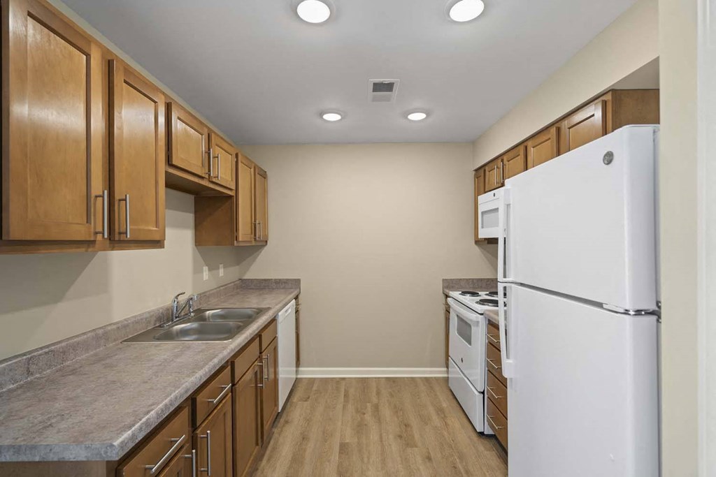 a kitchen with white appliances and wooden cabinets
