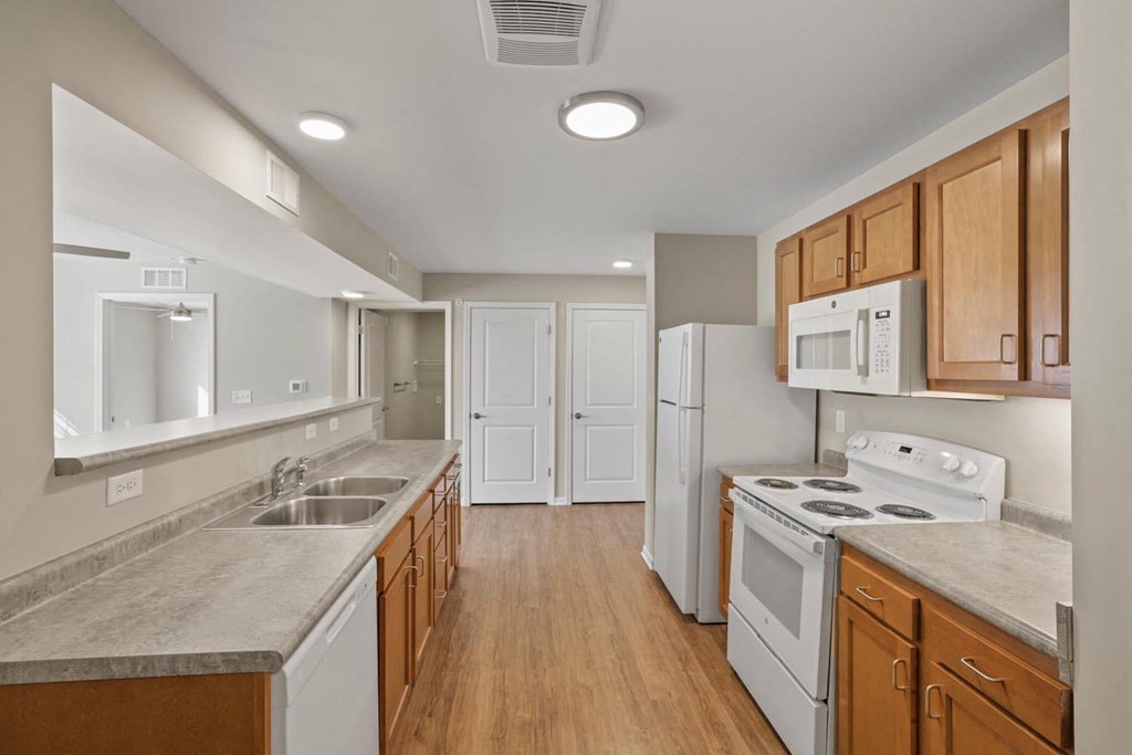 a kitchen with white appliances and wooden cabinets