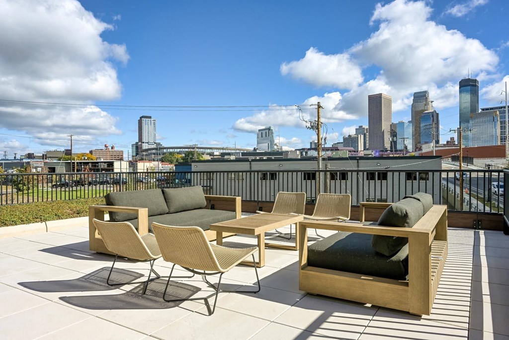 a roof deck with furniture and a city in the background