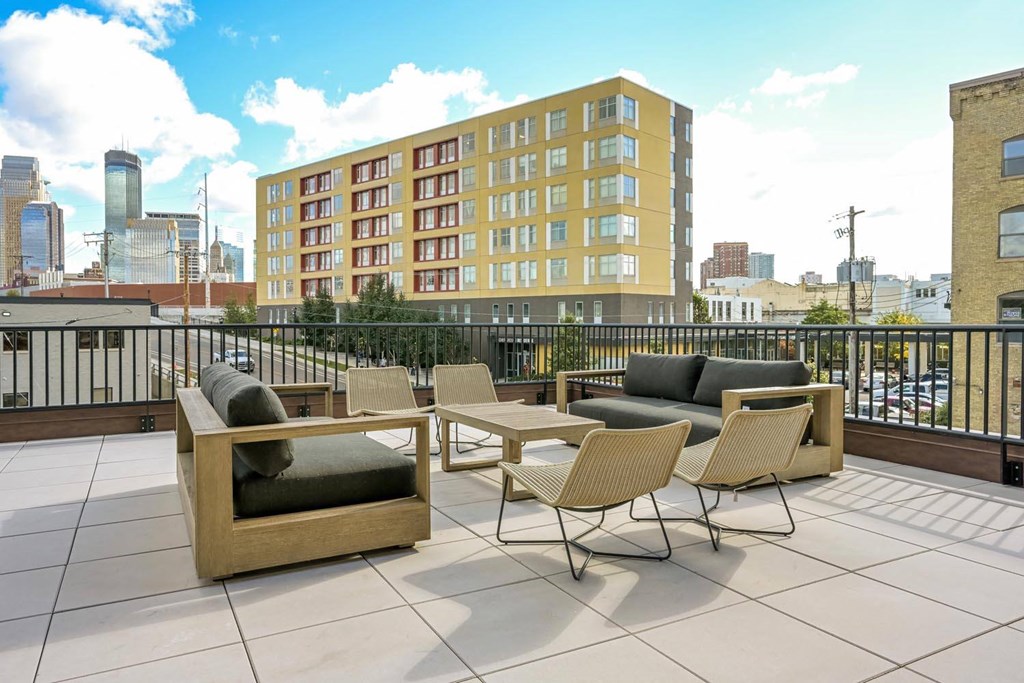 a rooftop patio with furniture and a view of the city