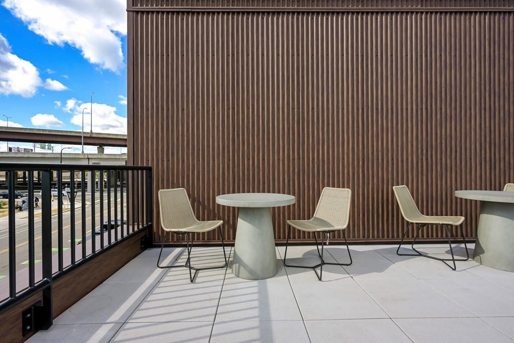 a terrace with tables and chairs and a wooden wall